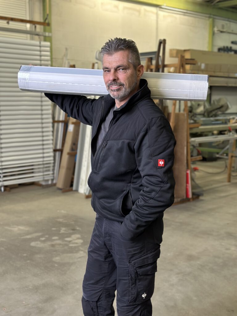 Foto eines Mitarbeiters mit Rolladen auf der Schulter